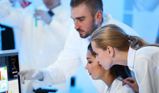 Team of lab techs looking at computer