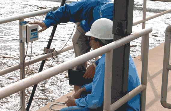 Two men looking at an instrument at a water treatment plant