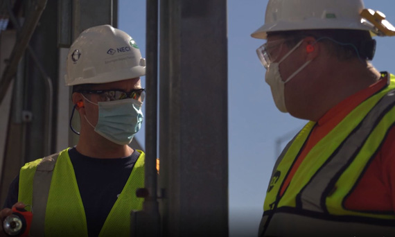 NECI technician in hardhat speaking with customer in hardhat, valve repair services, valve services